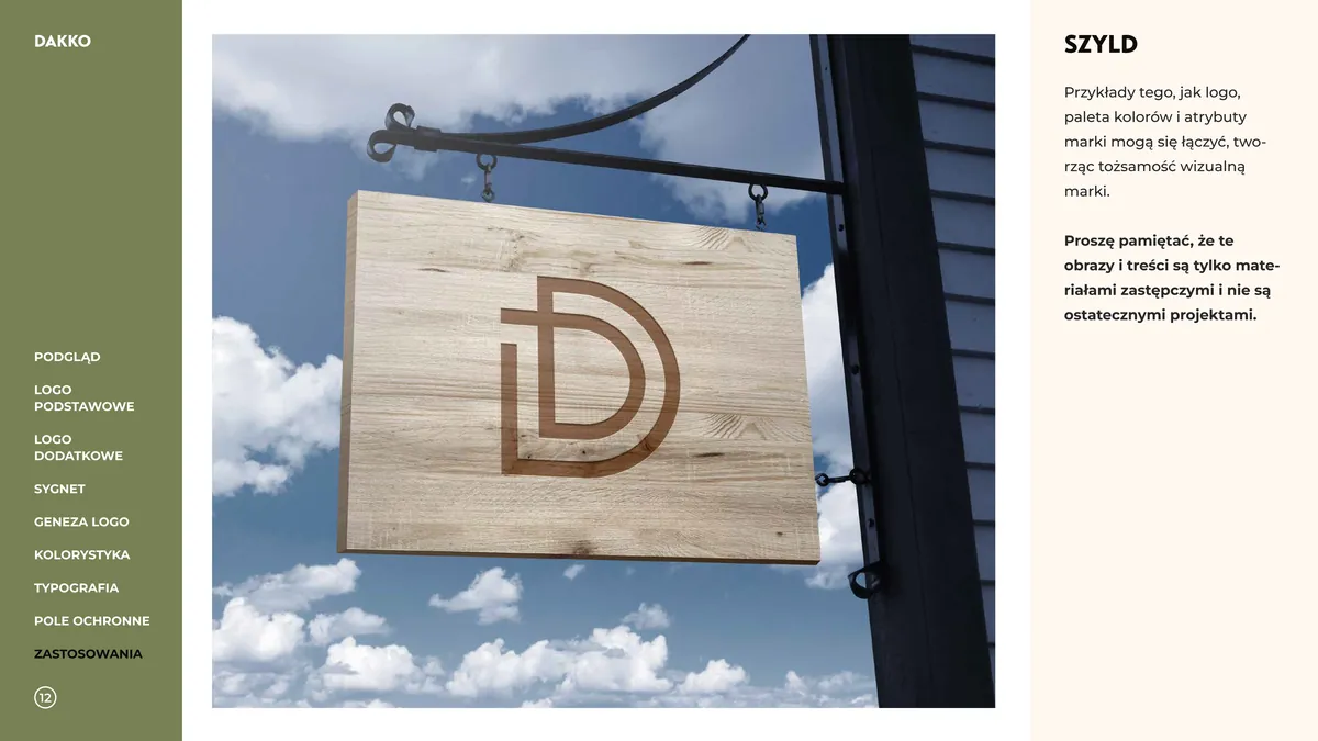 Dakko: drewniany szyld z wypalonym monogramem D na metalowym wysięgniku, w tle niebo z chmurami
