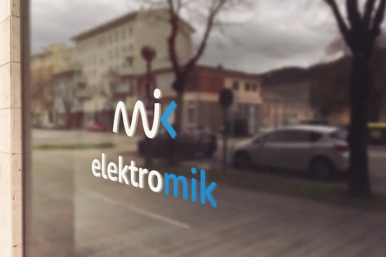 Elektromik: przestrzenne logo z sygnetem mik i napisem elektromik na szybie witryny