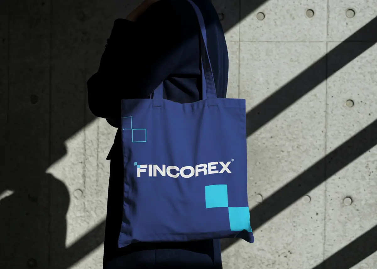 Fincorex: granatowa torba z białym logo i turkusowymi kwadratami na ramieniu osoby