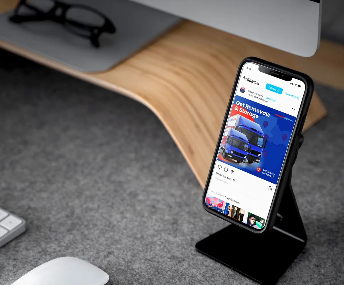 Happy2Move: post Get Removals & Storage z niebieską ciężarówką w telefonie na stojaku przy biurku