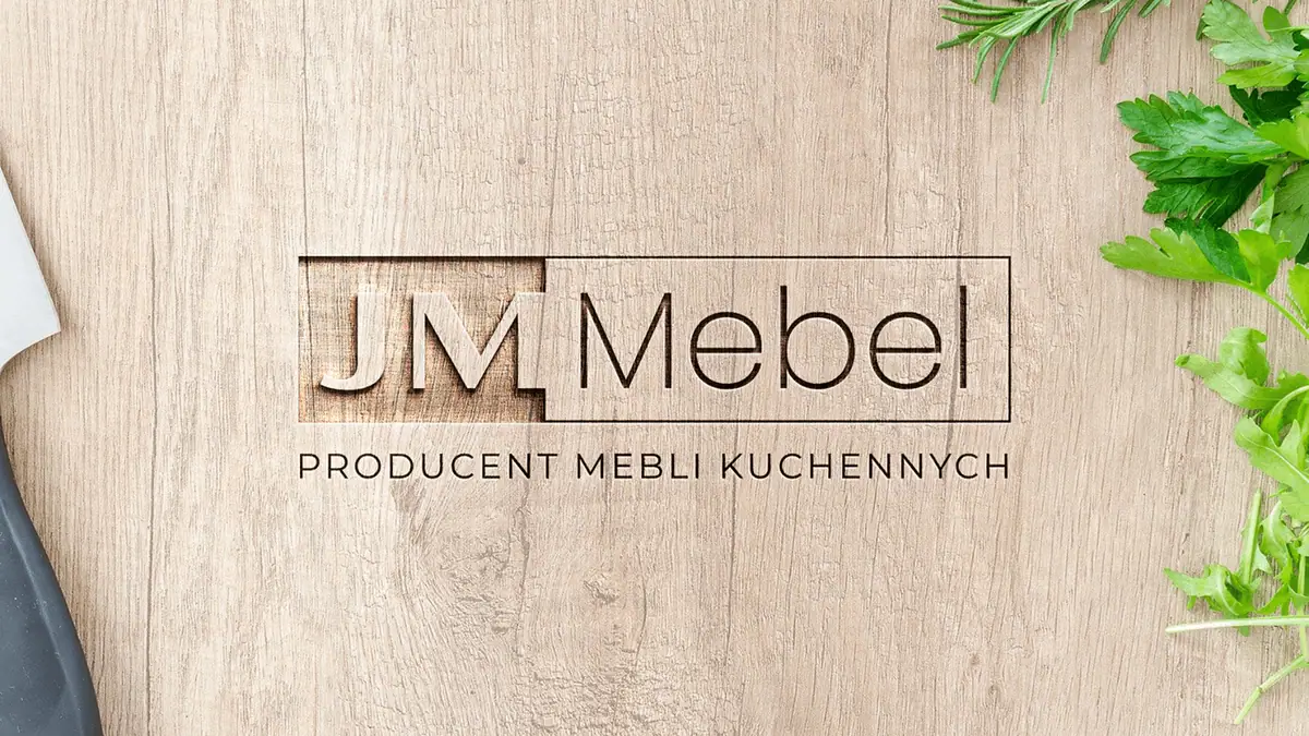JM Mebel: logo z dopiskiem Producent mebli kuchennych wyfrezowane w jasnej drewnianej desce