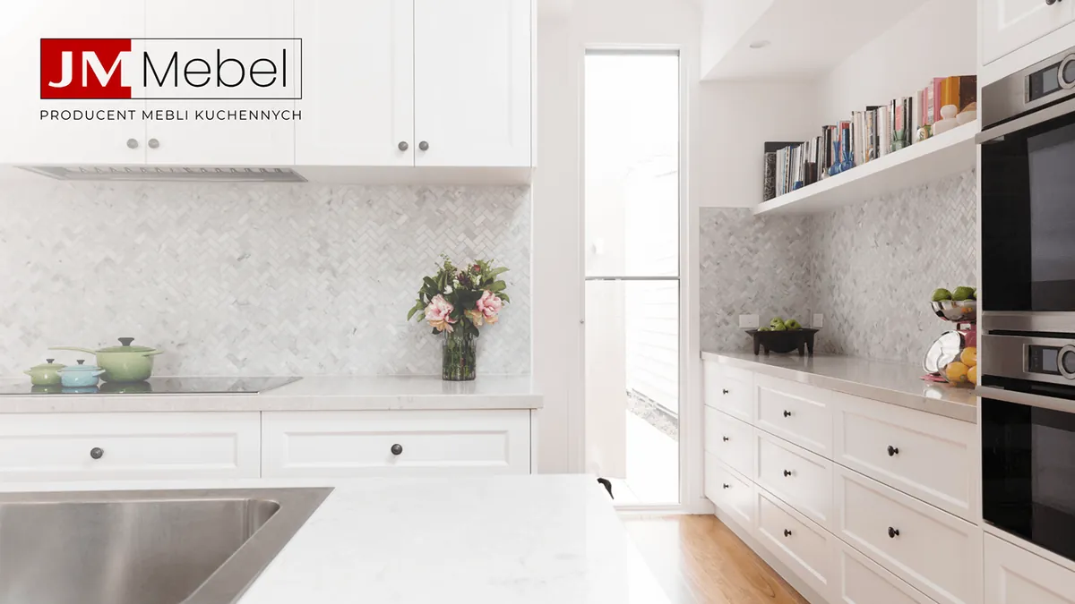 JM Mebel: white kitchen with a marble countertop, herringbone tiles and a bookshelf, logo in the left corner