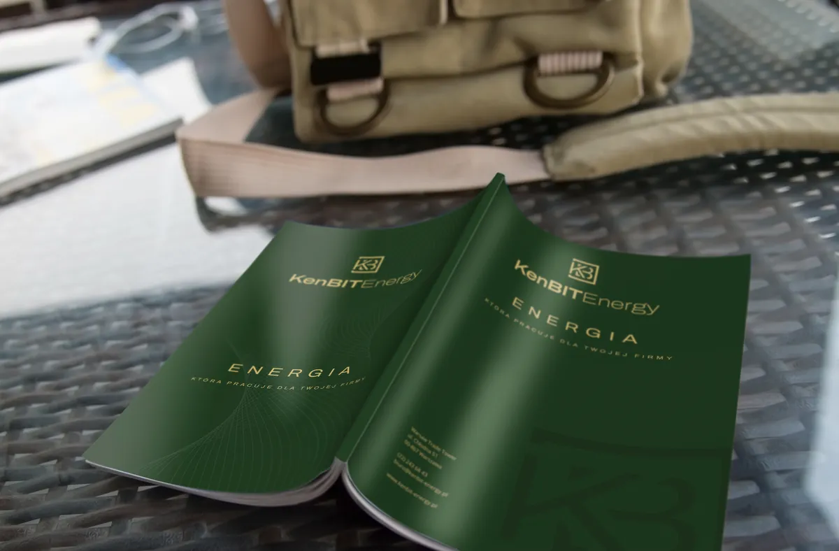 KenBIT Energy: green ENERGIA catalog cover with a gold logo on a wicker table next to a canvas bag