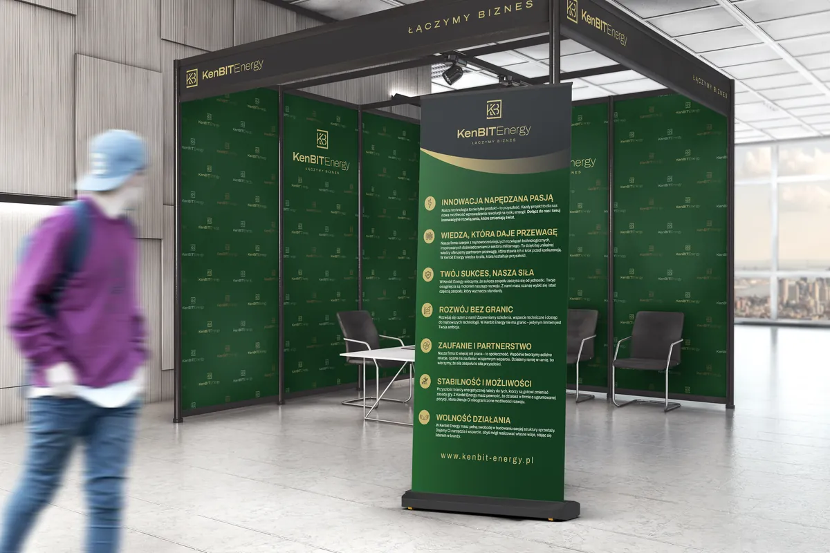 KenBIT Energy: trade fair booth with green backdrop walls with the logo, a green roll-up banner and a man walking past