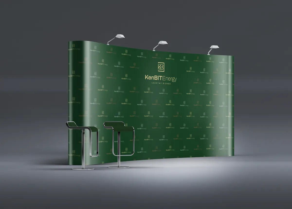 KenBIT Energy: łukowa zielona ścianka reklamowa z logo i wzorem z sygnetów, obok dwa hokery