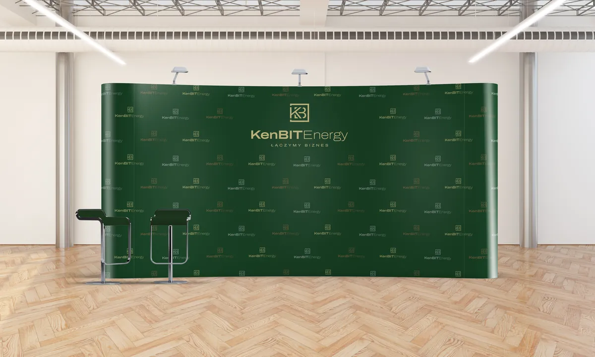 KenBIT Energy: zielona ścianka reklamowa z logo w jasnej hali z drewnianą podłogą i hokerami