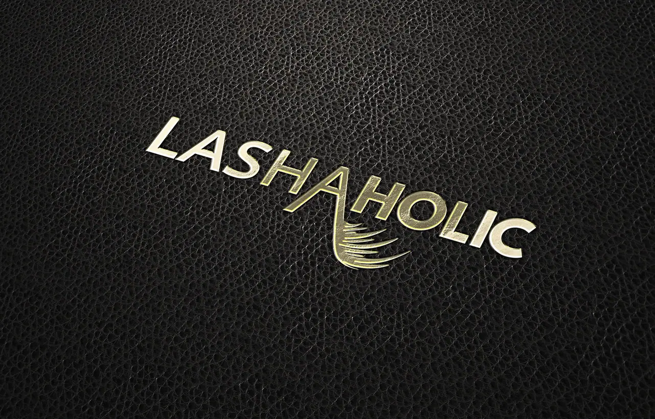 Lashaholic: logo tłoczone złotem na czarnej skórze, litera A z rzęsami
