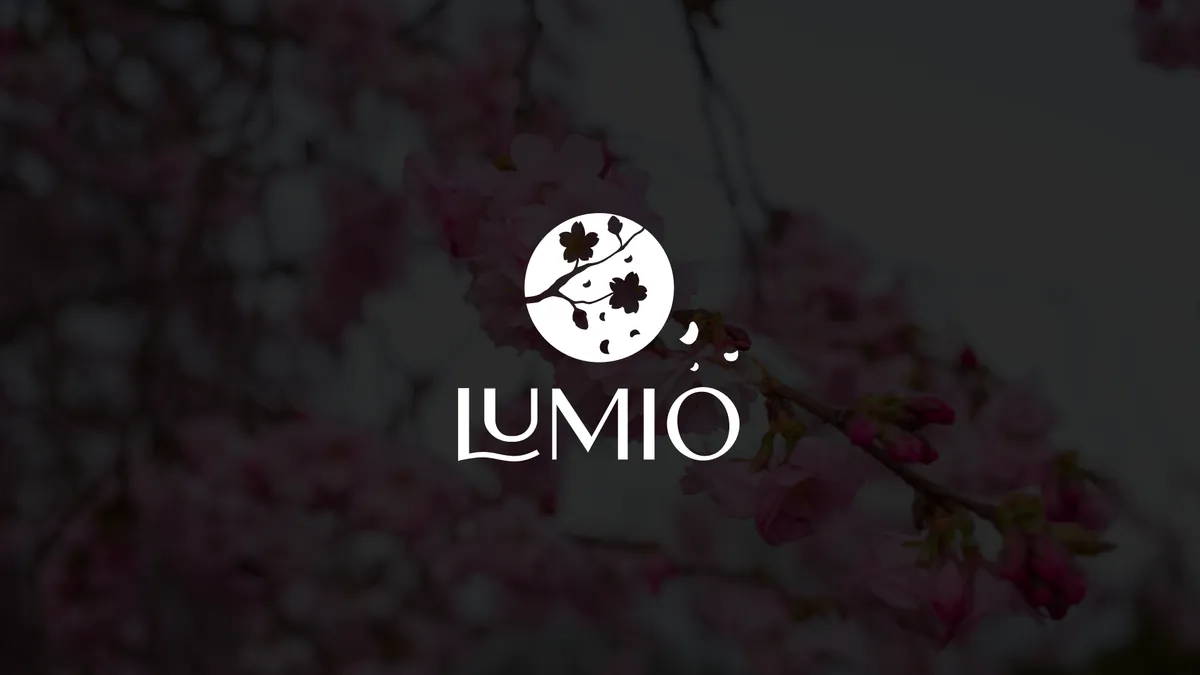 Lumio: white logo with the blooming branch brandmark on a darkened photo of cherry blossoms