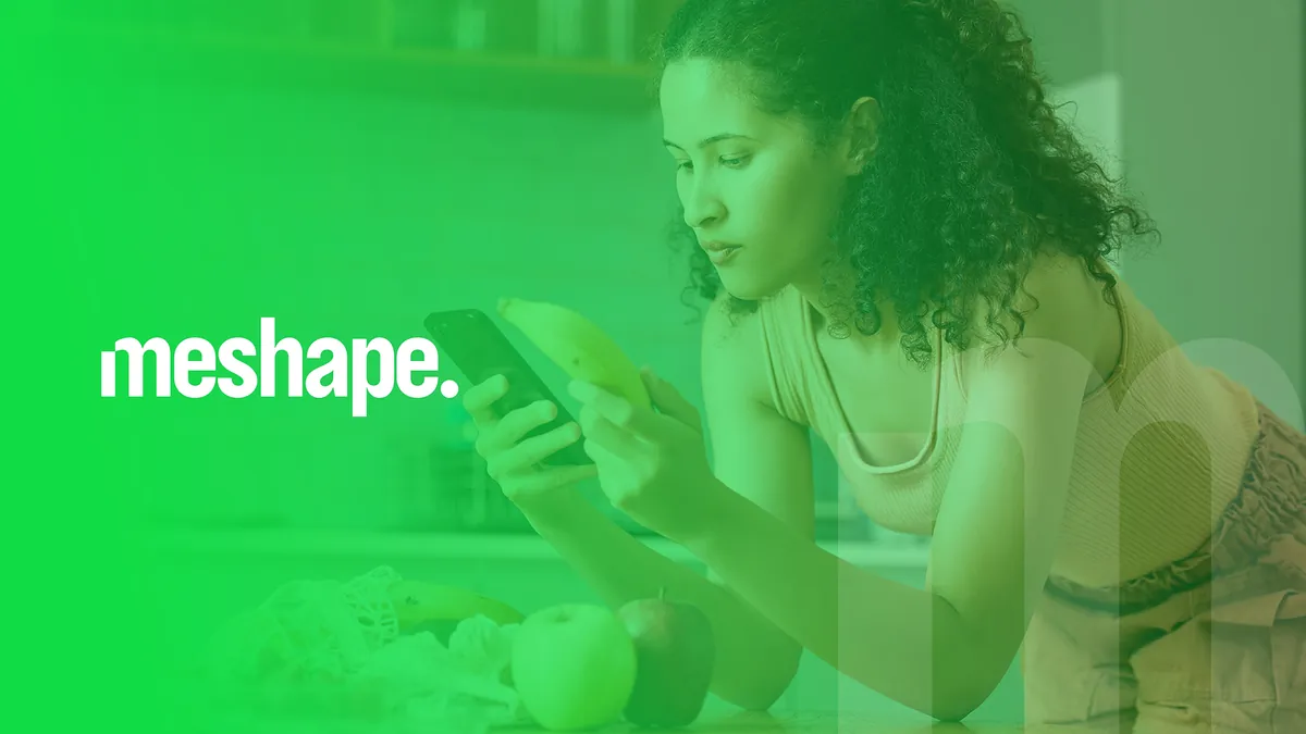 MeShape: białe logo meshape. na zielonym zdjęciu kobiety z telefonem i owocami w kuchni