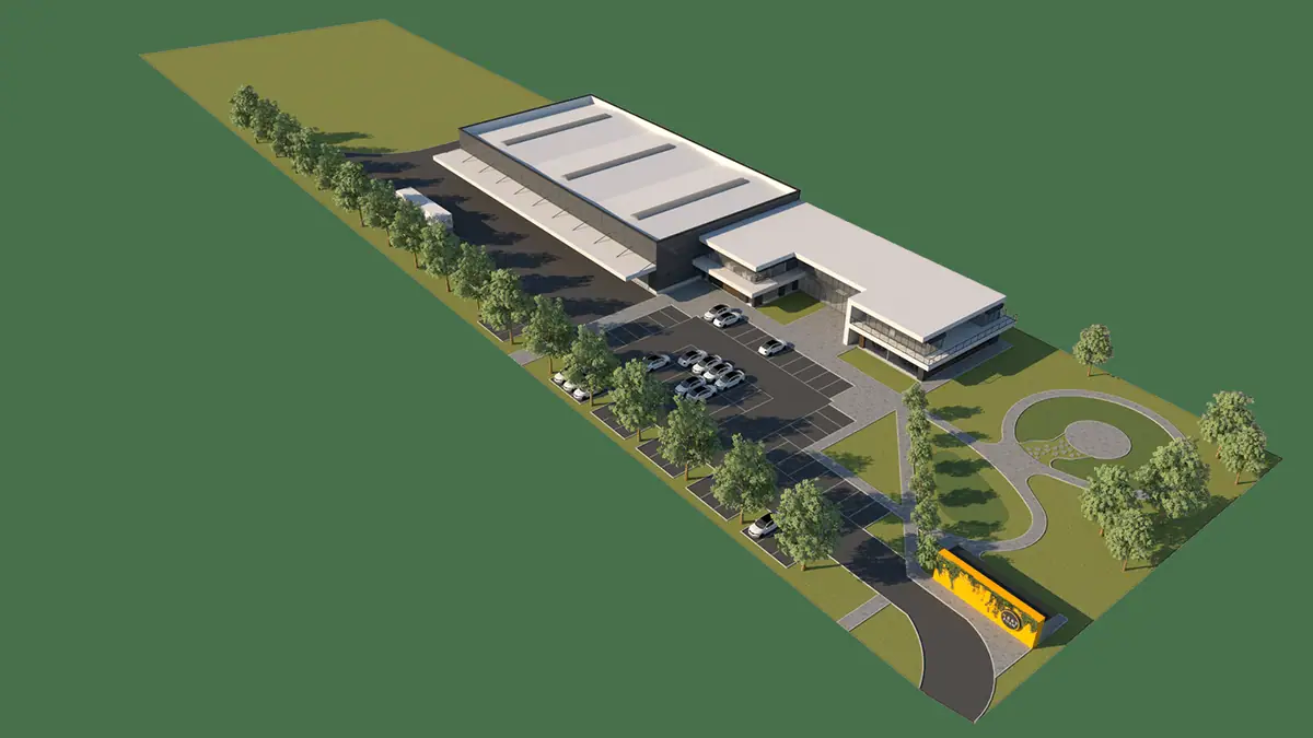 Nestfoam: widok z lotu ptaka na halę z biurami, parking, szpaler drzew i żółty mur przy wjeździe